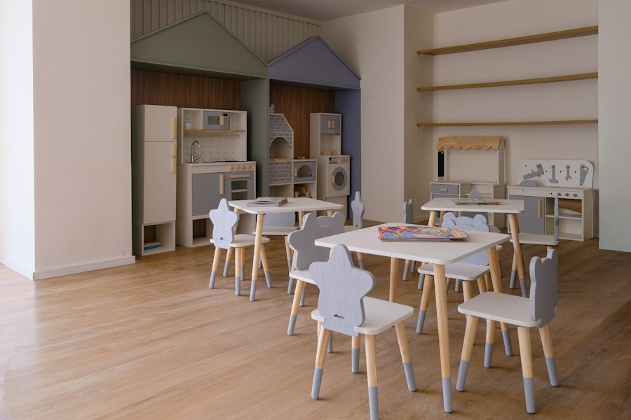A bright, tidy preschool classroom with small tables and chairs